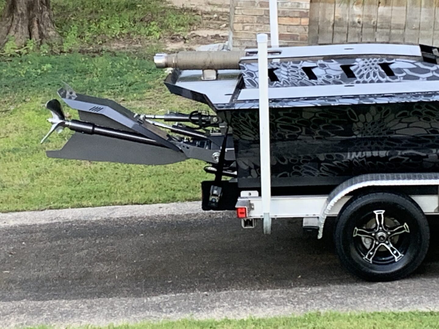 The back of a black boat loaded on a trailer.