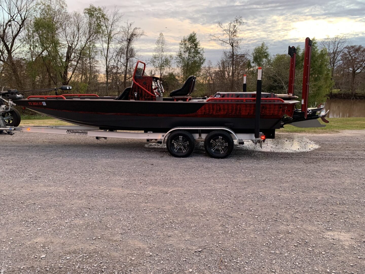 A red color speed boat loaded onto a trailer and being trnaported.