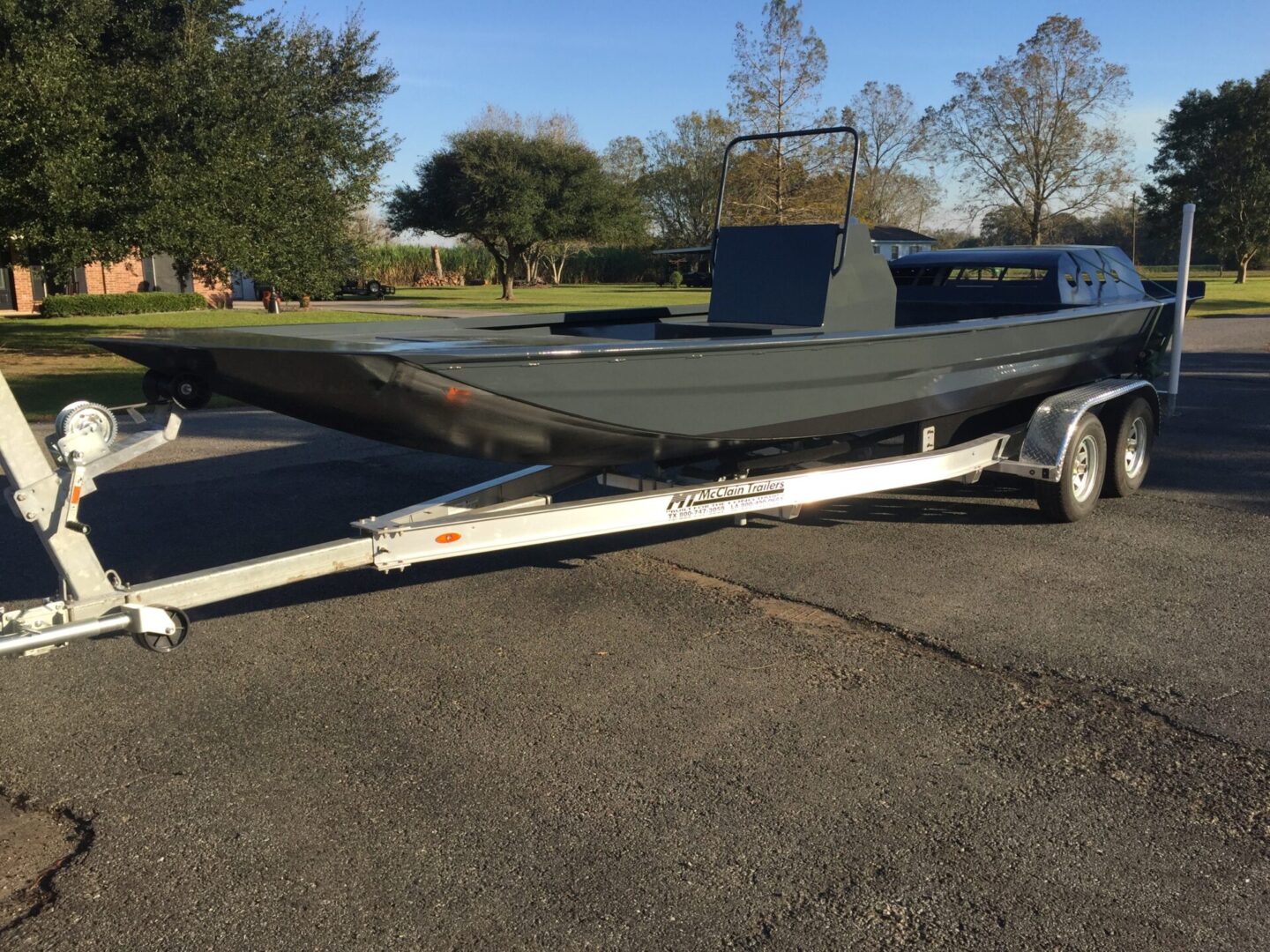 A black speed boat loaded onto a trailer and transpoted.
